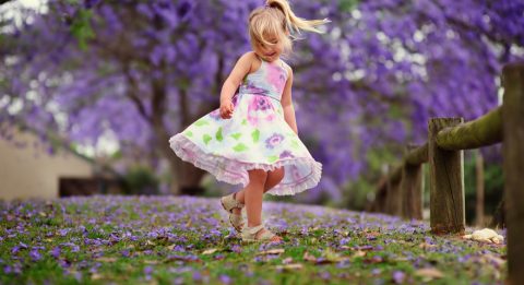 small girl in leaves during spring